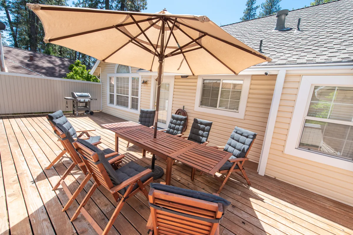 Back deck with a shaded dining table among the trees