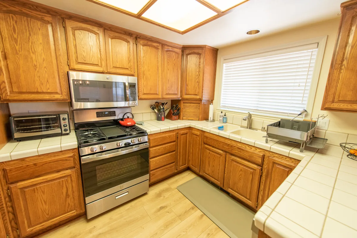 Oak kitchen with a gas range and tile counters